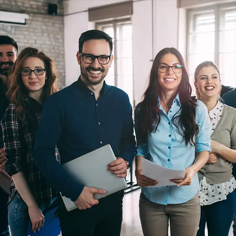 A group of smiling business professionals confidently looking at the camera.